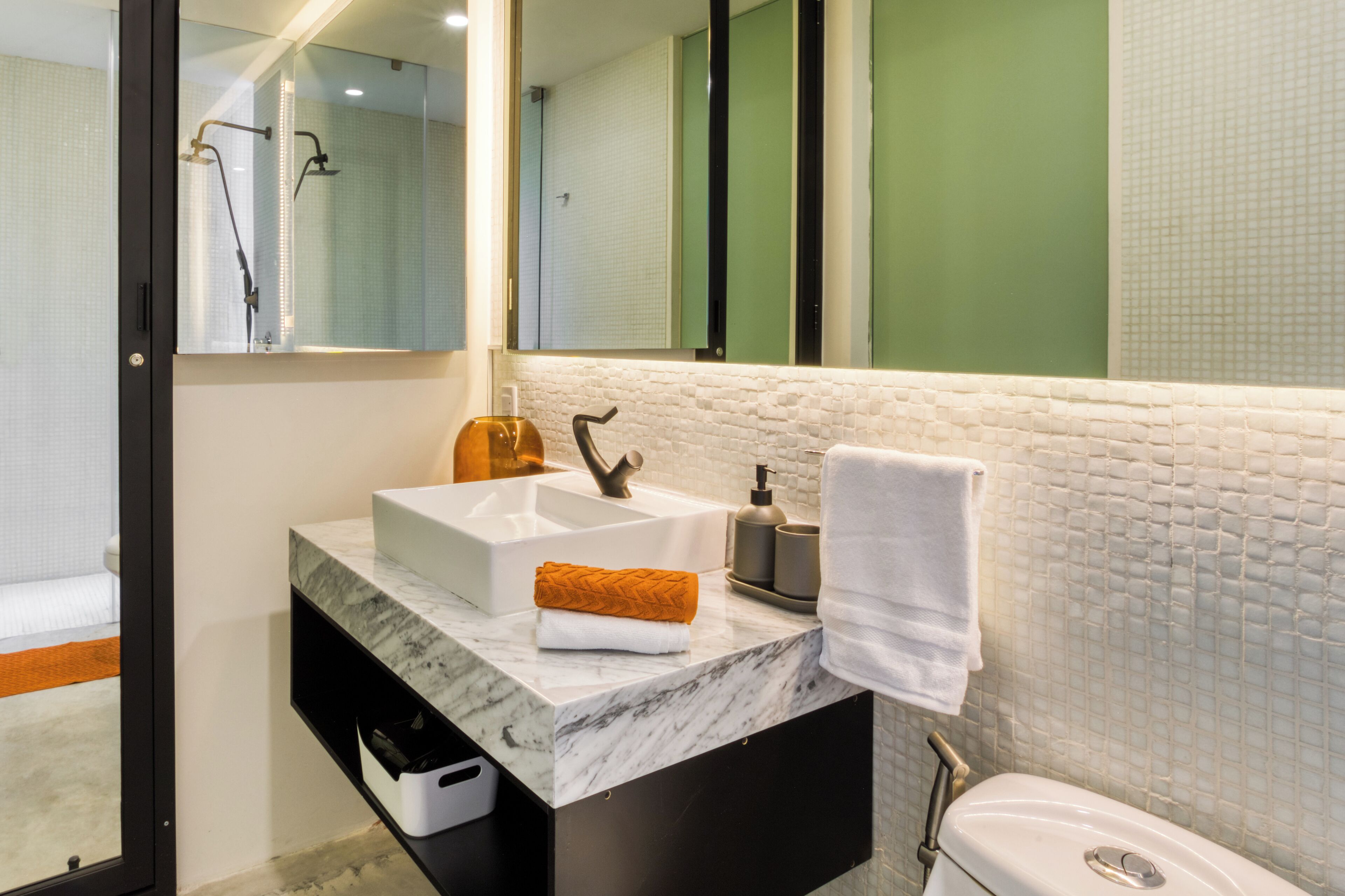 Un baño moderno con un lavabo blanco, un espejo y una ducha.