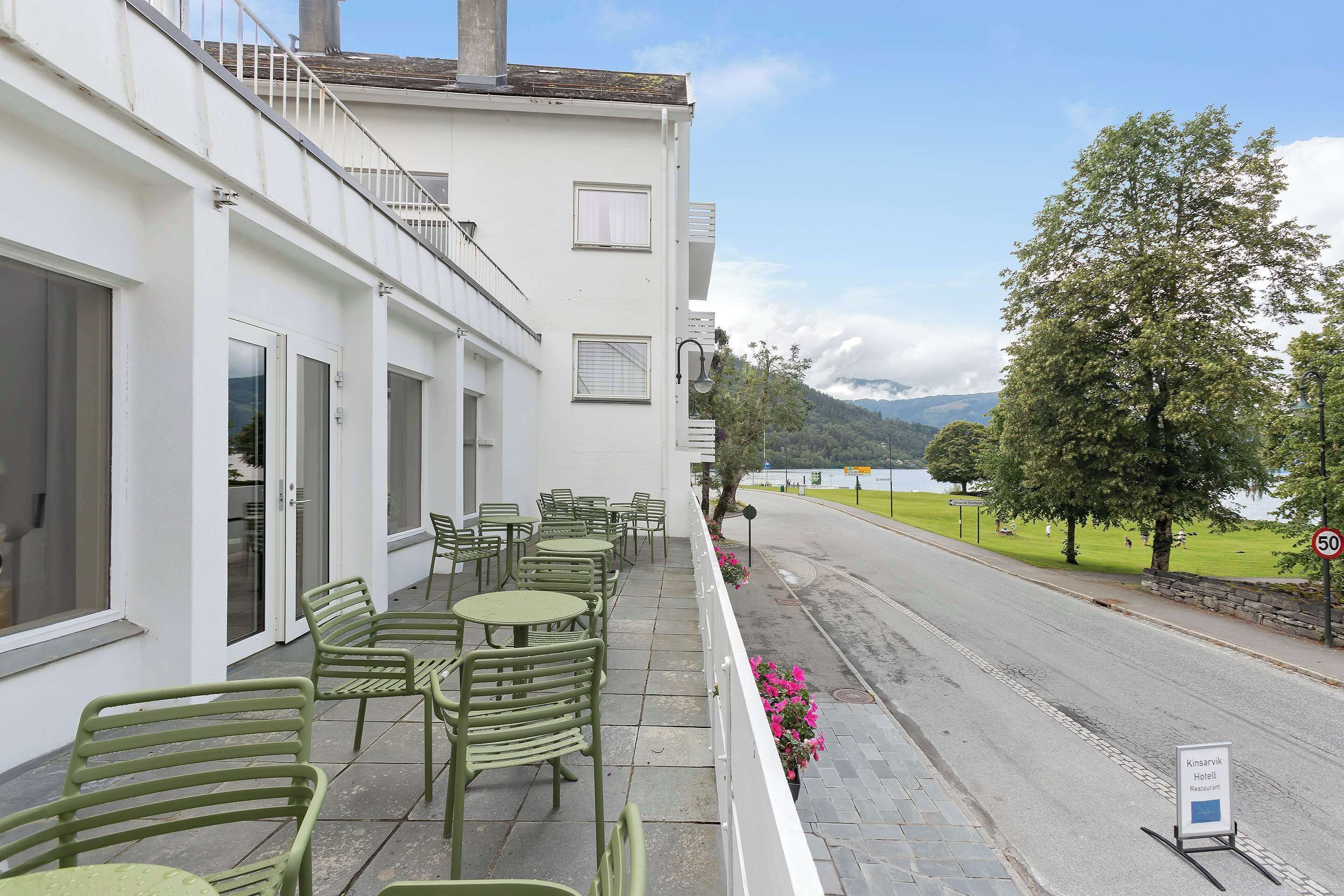A hotel with outdoor seating, a view of the lake, and a speed limit sign.