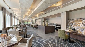 Eine geräumige Hotelhalle mit einer zentralen Insellounge, einem Essbereich und einem strukturierten Boden.