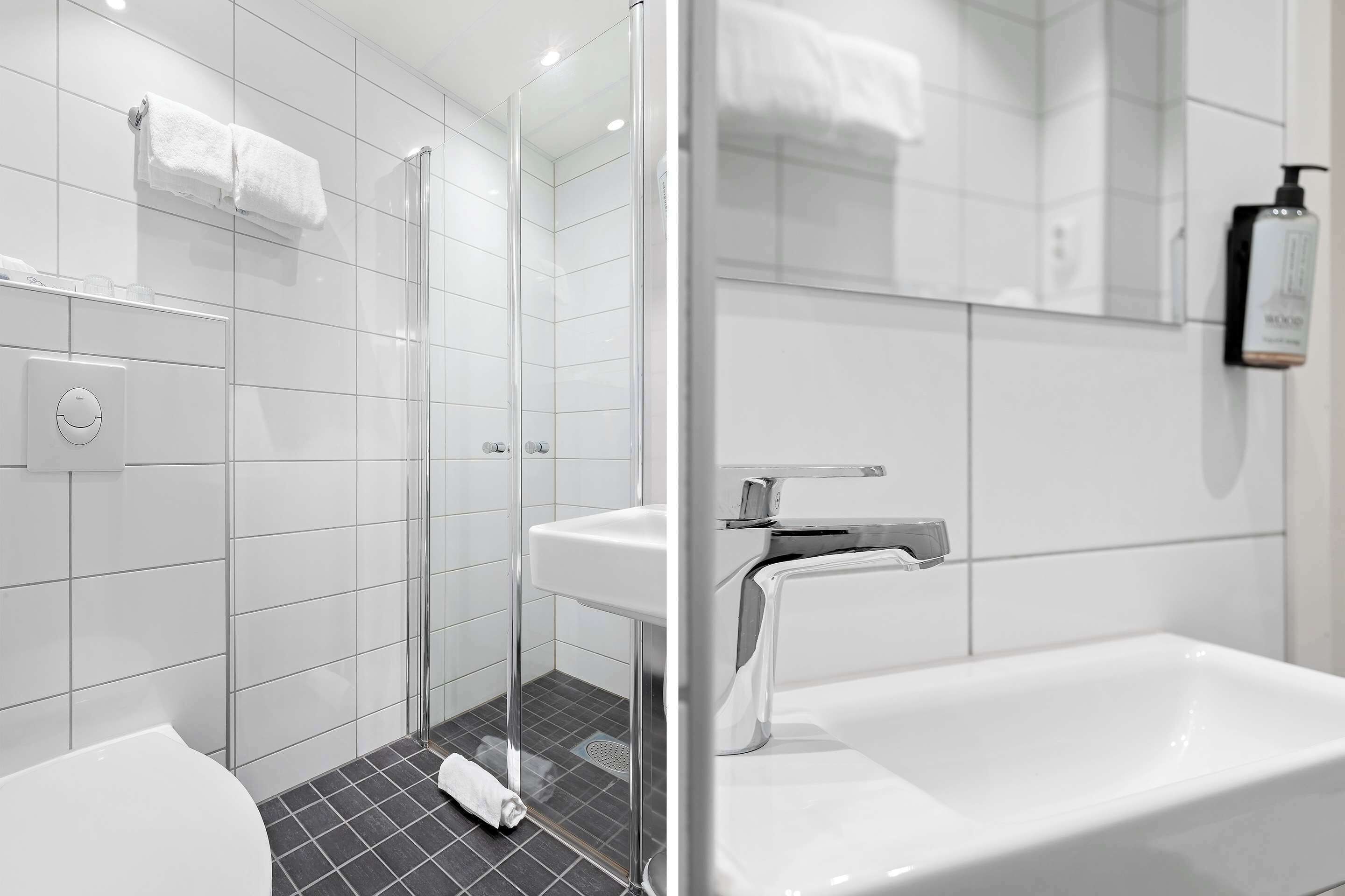 Un baño moderno con mampara de vidrio, un lavamanos blanco y una bañera grande.