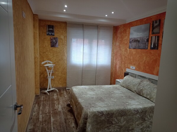 Relax in a cozy space with a large bed, framed pictures, and a comfortable chair.