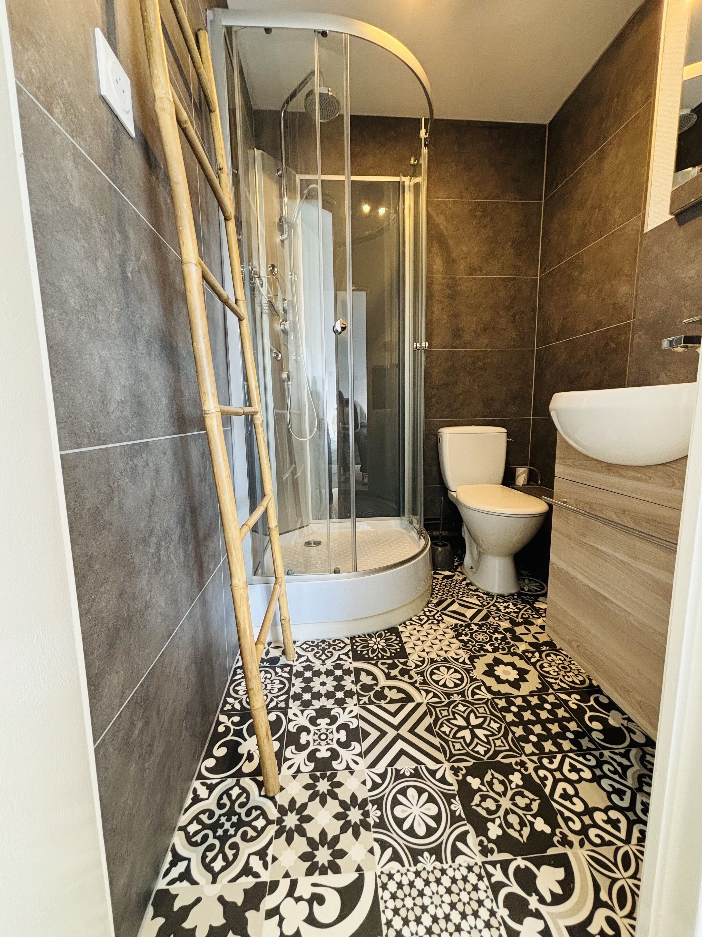 Une salle de bain équipée d’une douche, de toilettes et d’un lavabo.