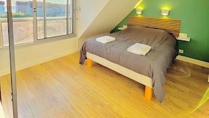 A bedroom with a bed, a window, and a green wall. - L'escapade Vue Mer - Hardelot (Neufchâtel-Hardelot)