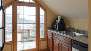 A kitchen with a wooden door leading to a balcony, a sink, a microwave, and a dishwasher. - Spacious Private Suite with full kitchen, private deck and pet friendly! (Blowing Rock)