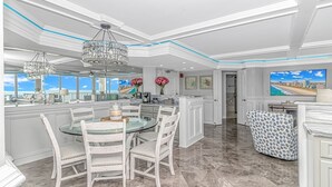 A spacious kitchen with a large island, modern pendant lights, and a view of the cityscape through large windows. - Experience Coastal Luxury: 2-Bedroom Oceanfront Condo in Myrtle Beach! (Myrtle Beach)