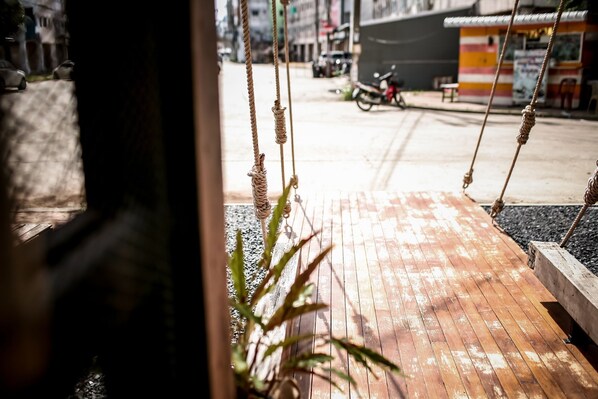 A wooden deck with ropes, a motorcycle, and a building in the background.