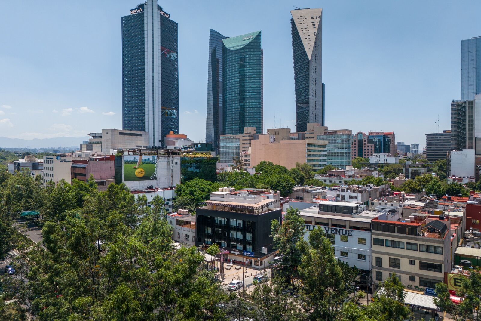 Paesaggio urbano con moderni grattacieli, un mix di edifici commerciali e residenziali e un grande cartellone pubblicitario.