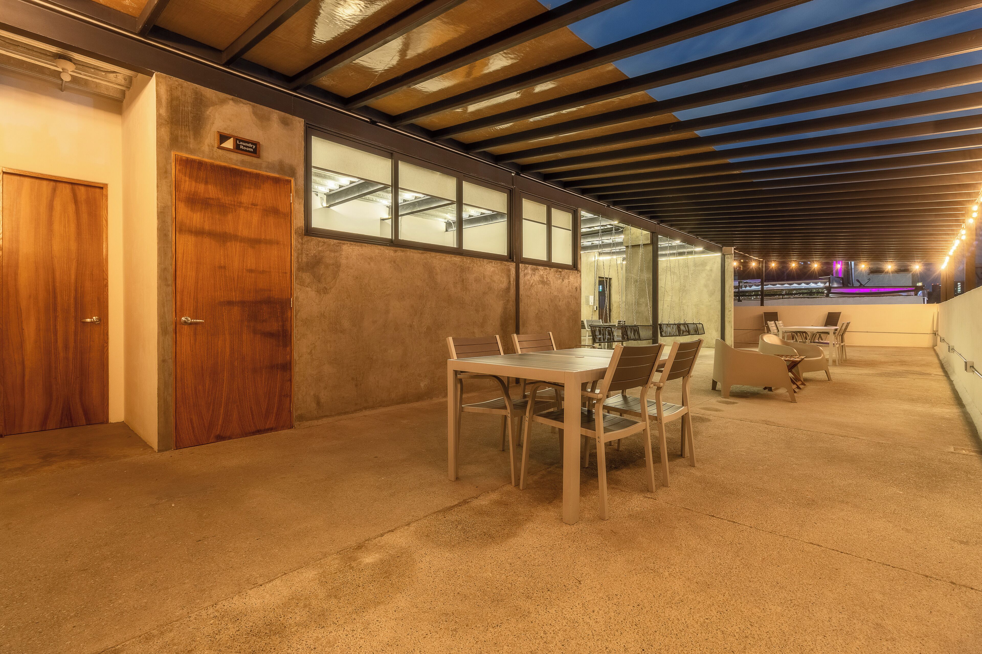 A modern interior with a concrete floor, wooden doors, and a table with chairs.