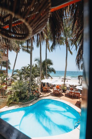 A pool area with palm trees and beach views. - LOS CORALES (Máncora)