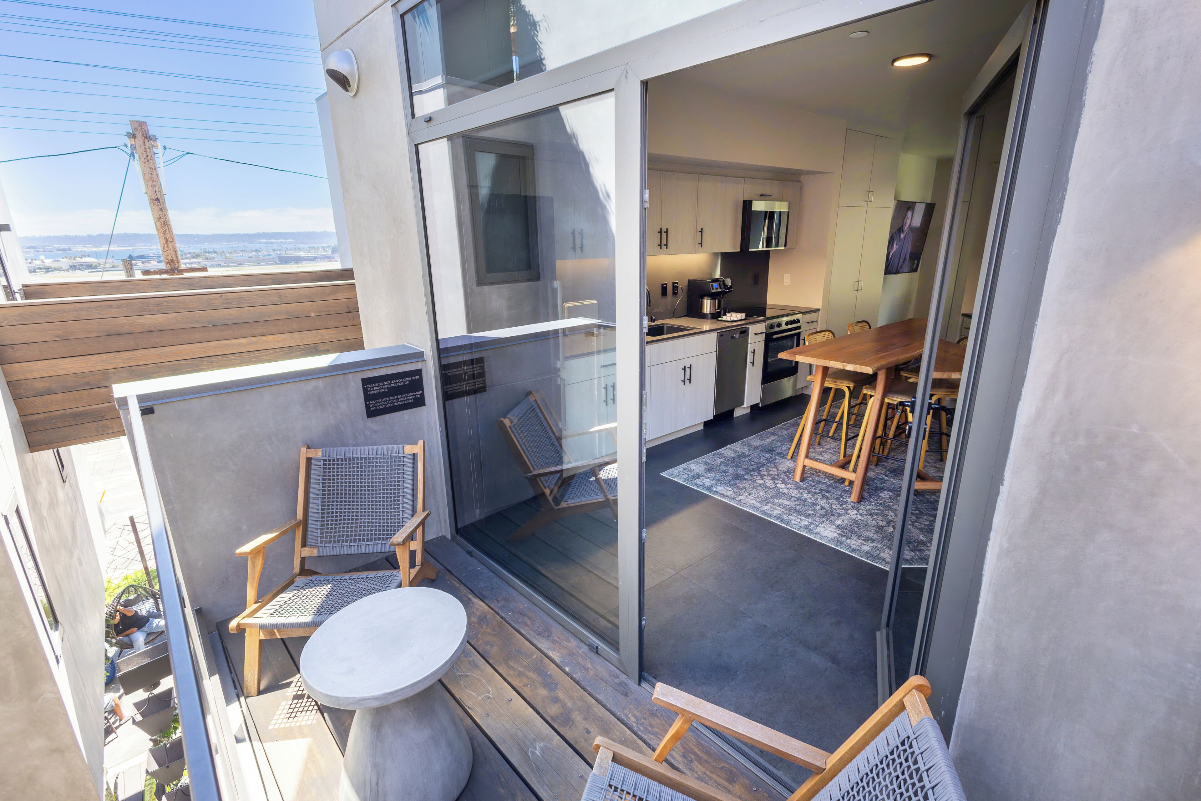 Een moderne keuken met een eetgedeelte, een balkon met zitplaatsen en uitzicht op de stad.