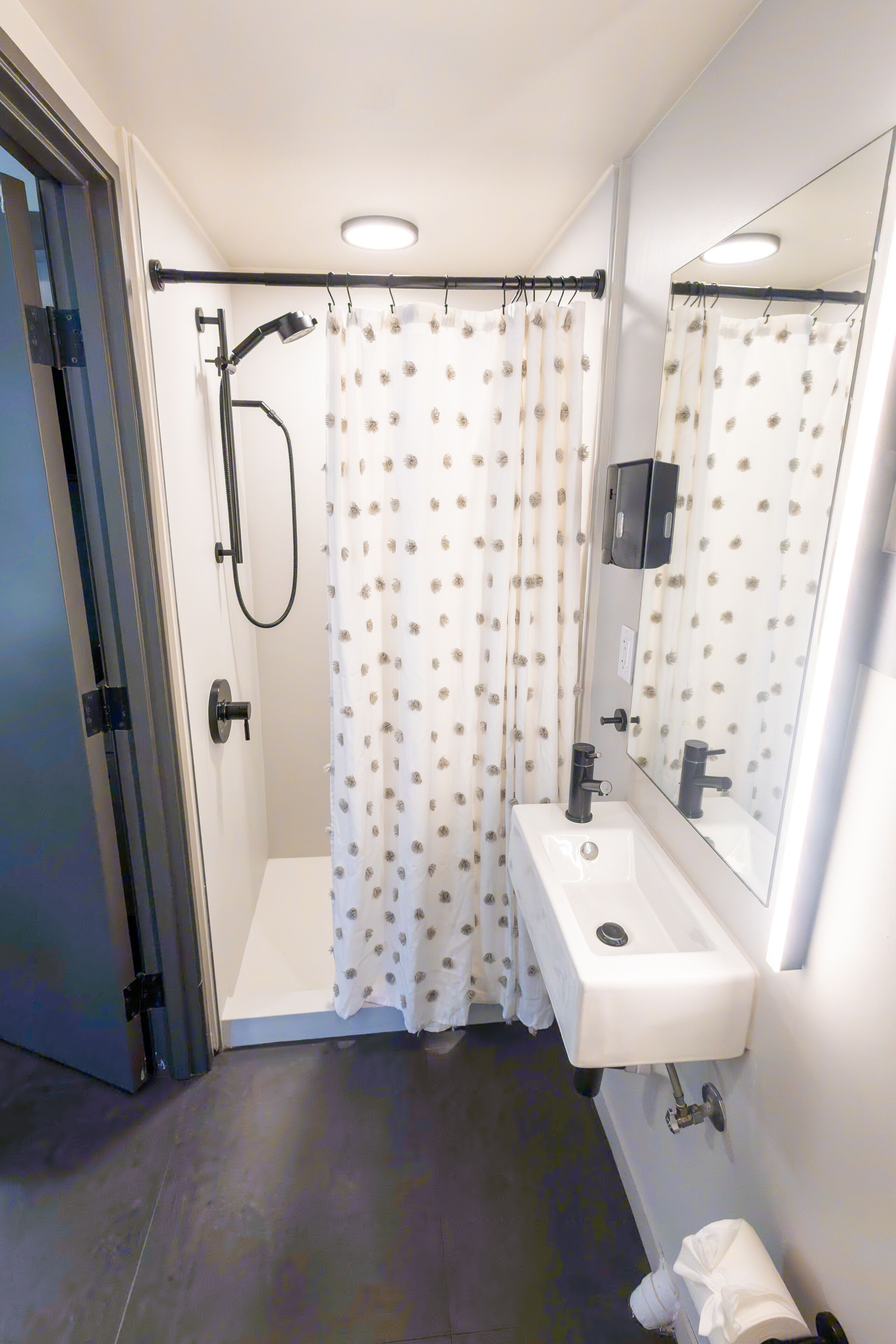 Ein modernes Badezimmer mit Dusche, Waschbecken und Spiegel.