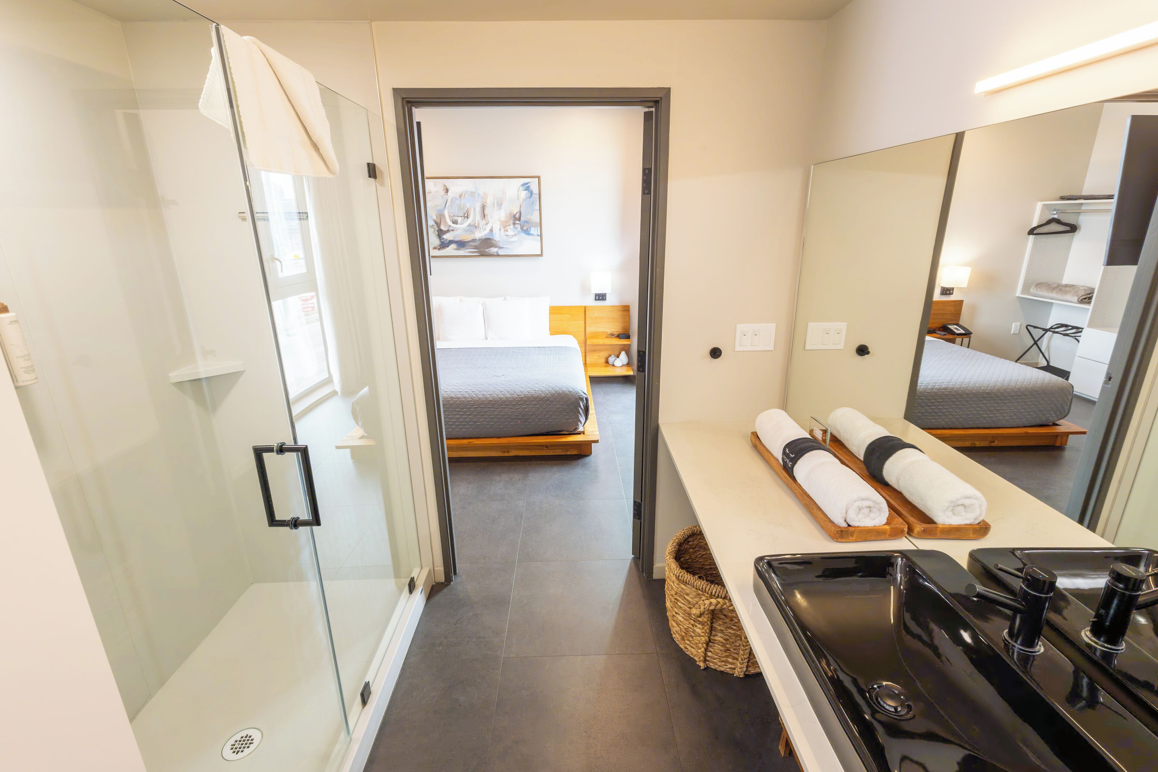 A modern bathroom with a shower, a sink, and a mirror.