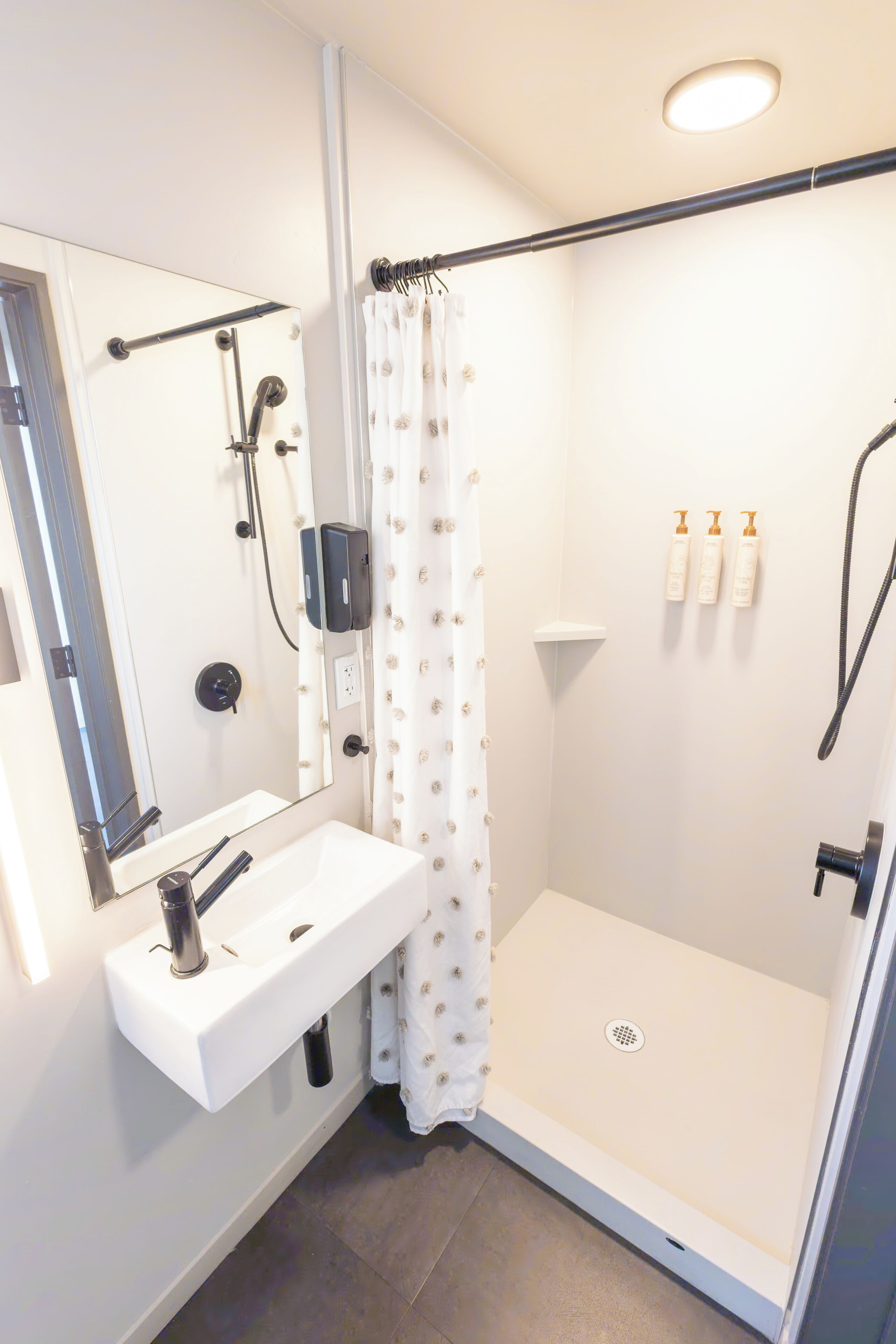 Un baño moderno con ducha, lavamanos y espejo.