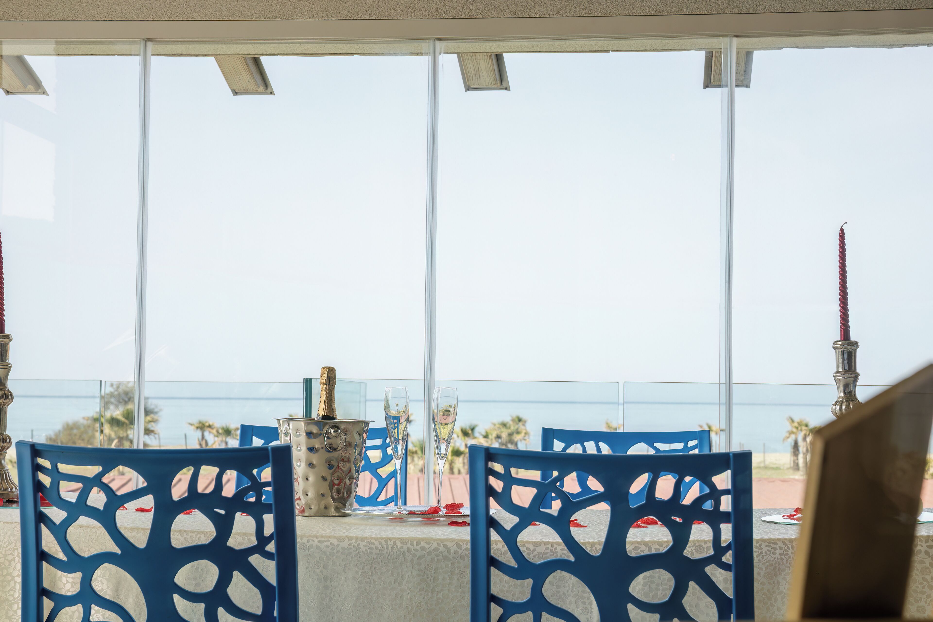 A table set with blue chairs, a champagne bucket, and two glasses.