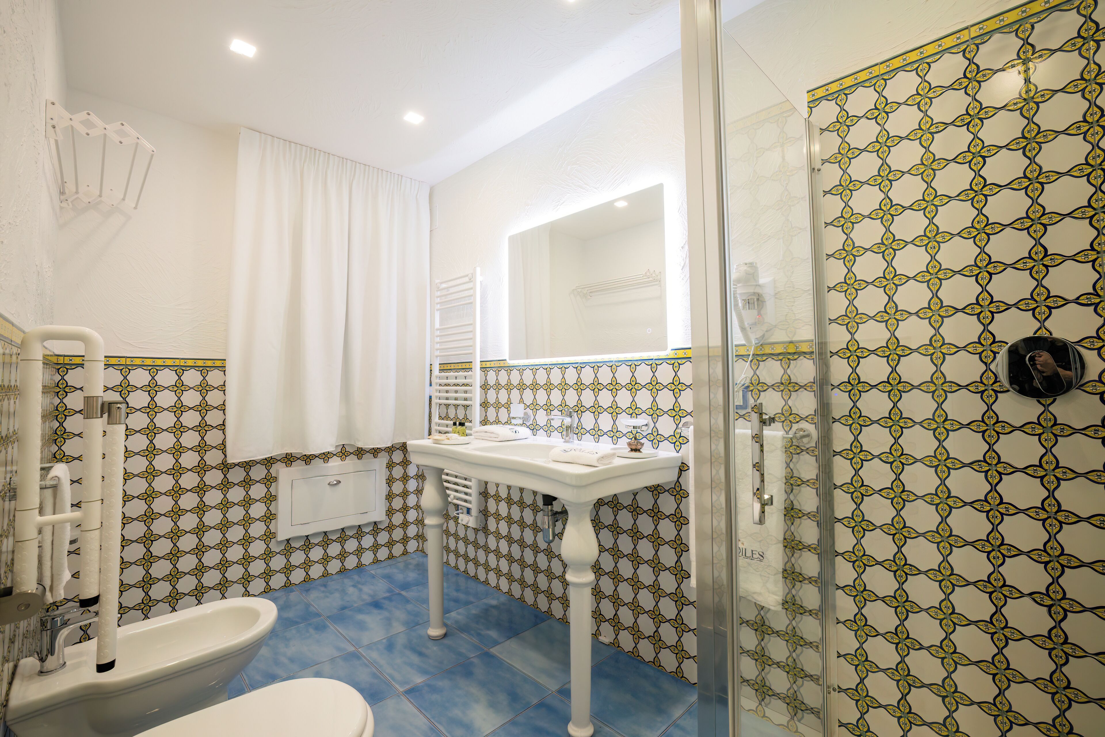 A bathroom with a white sink, a mirror, and a shower area.