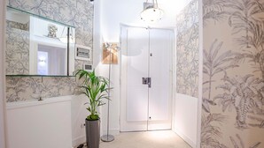 A narrow hallway with a white door, a large mirror, and a potted plant. - Stilysh apartment in Rome close to cafes, restaurants, bus and metro. (Roma)
