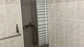 Een douche, handdoeken, zeep, shampoo