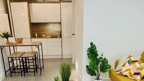 Un espace de vie moderne avec une table à manger en bois, un canapé jaune et des plantes en pot.