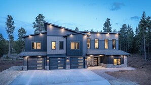 Een modern huis met twee verdiepingen, een garage, grote ramen en een oprit.