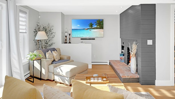 A modern living room with a flat-screen TV, a fireplace, and a comfortable seating area. - Scenic 4BR/3BA Waterfront Getaway with private dock, kayaks & Stunning Views (Dartmouth)