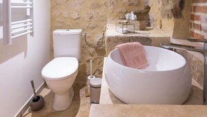 A bathroom with a toilet, a sink, and a freestanding bathtub.