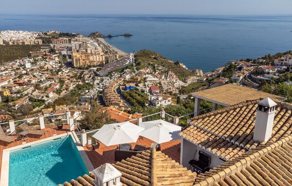 Une piscine sur le toit offrant une vue dégagée sur la mer et, au loin, sur un quartier résidentiel.