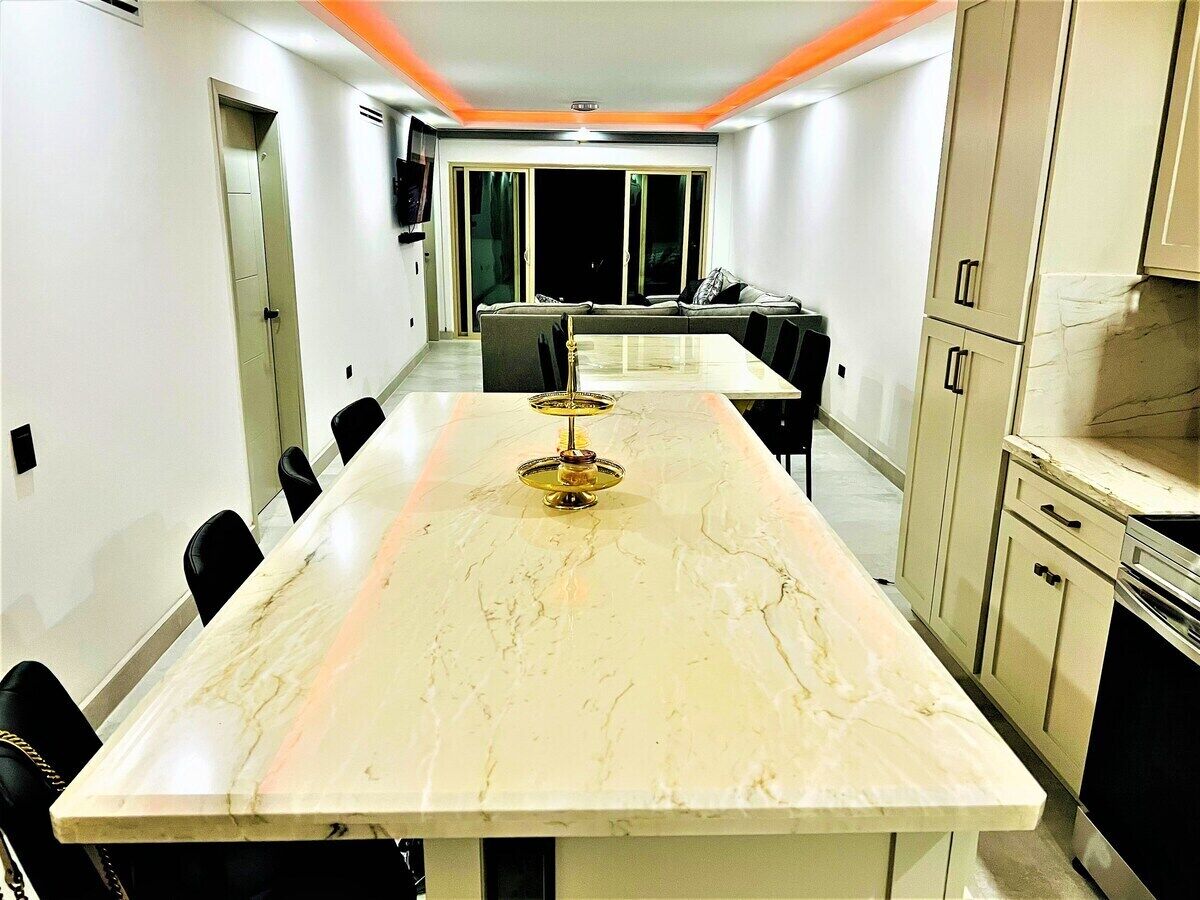 Un salón de conferencias con una mesa de mármol, sillas negras y un sofá.