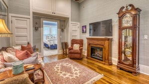 A living room with a fireplace, a television mounted on the wall, and a large mirror.