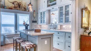 A kitchen with a large island, bar stools, and a window with a view.