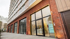 A modern building with large glass windows and a brick facade. - Ocean VIEW, Pool&Coworking, Queen Bed 19th floor (Barranco)