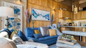 A modern living room with a blue sofa, a grey ottoman, and a coffee table with decorative items. - SAN LUIS POTOSI by Mr. W (Mexico City)