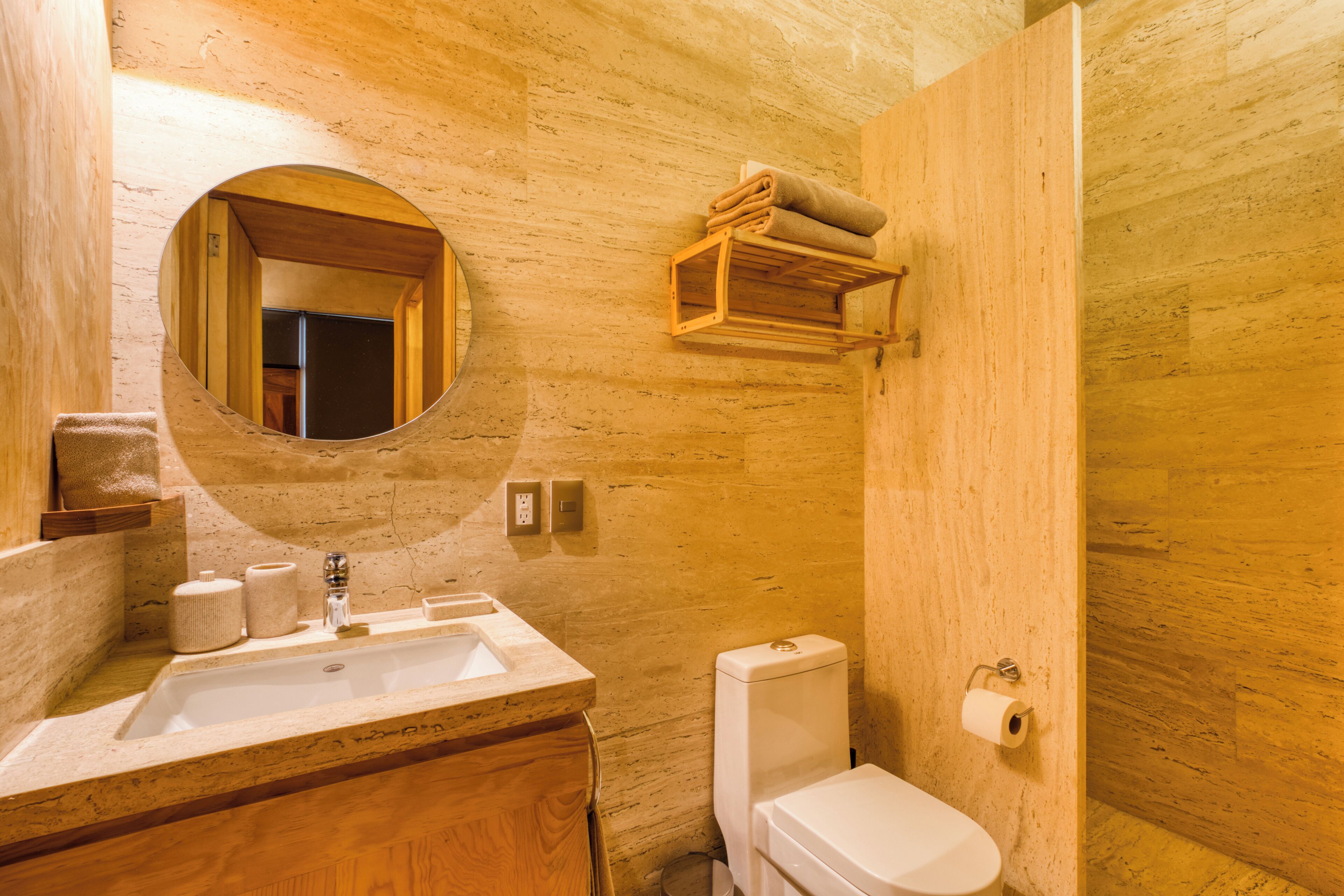 Une salle de bain avec un meuble-lavabo en bois, un évier, des toilettes et un miroir.