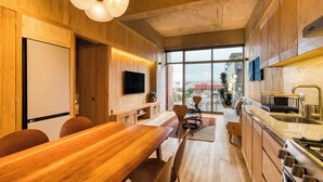 A modern kitchen with wooden cabinetry, a built-in oven, and a large window offering a city view. - SAN LUIS POTOSI by Mr. W (Mexico City)