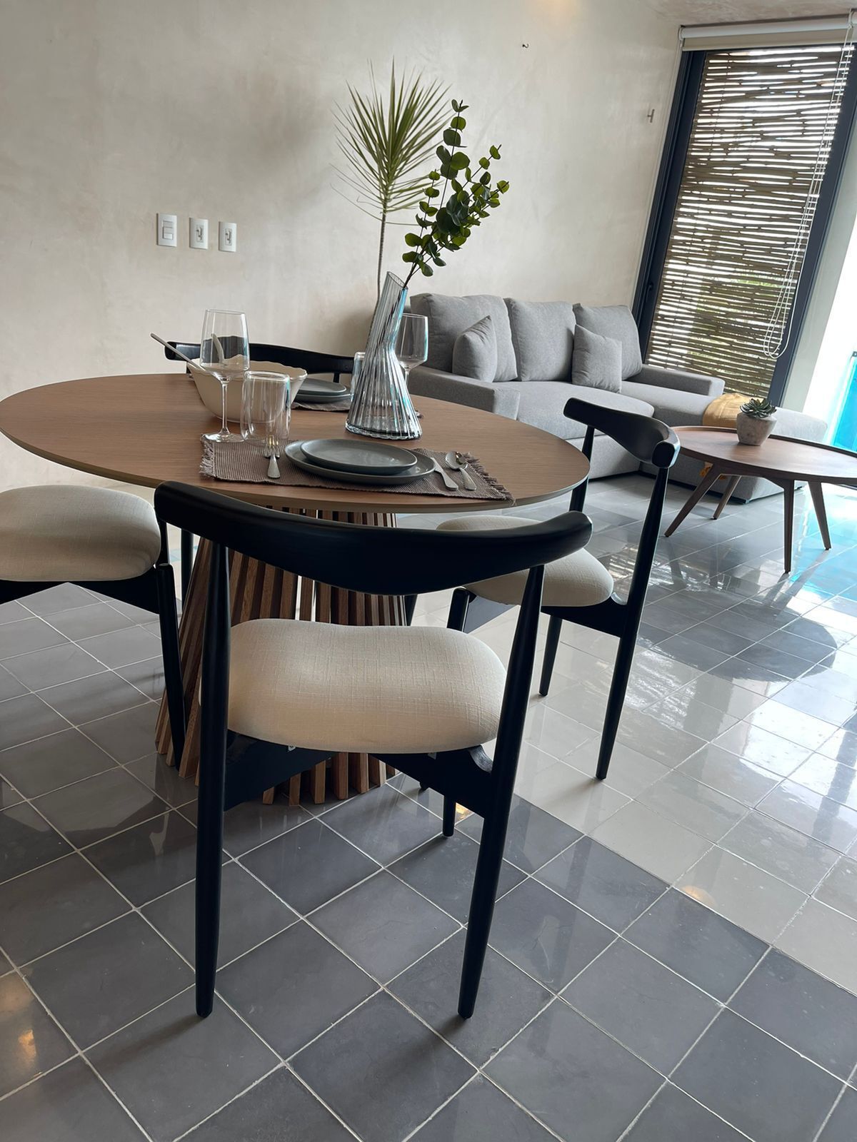 Un comedor moderno con una mesa redonda, sillas y una planta en maceta.