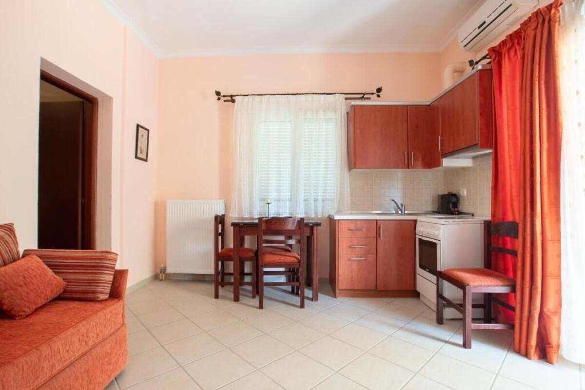 A compact kitchen with a dining table, chairs, and a built-in oven.