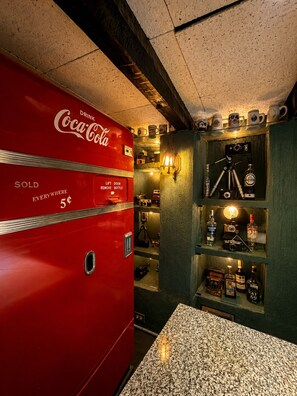 Un distributeur automatique de Coca-Cola d’époque, doté d’une porte à ouverture verticale et d’une étiquette indiquant « VENDU ».