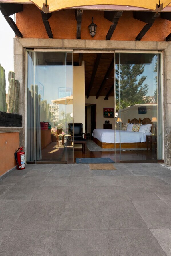 Ein modernes Schlafzimmer mit Glastür, die auf eine Terrasse führt.