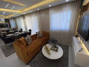 A modern living room with a sofa, coffee table, and TV. - Luxurious and modern apartment 10 minutes from the aero port  (Santo Domingo Este)