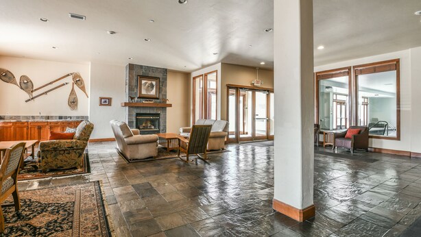 A spacious living area with a fireplace, comfortable seating, and a large window providing natural light. - Oro Grande 308 (Keystone)