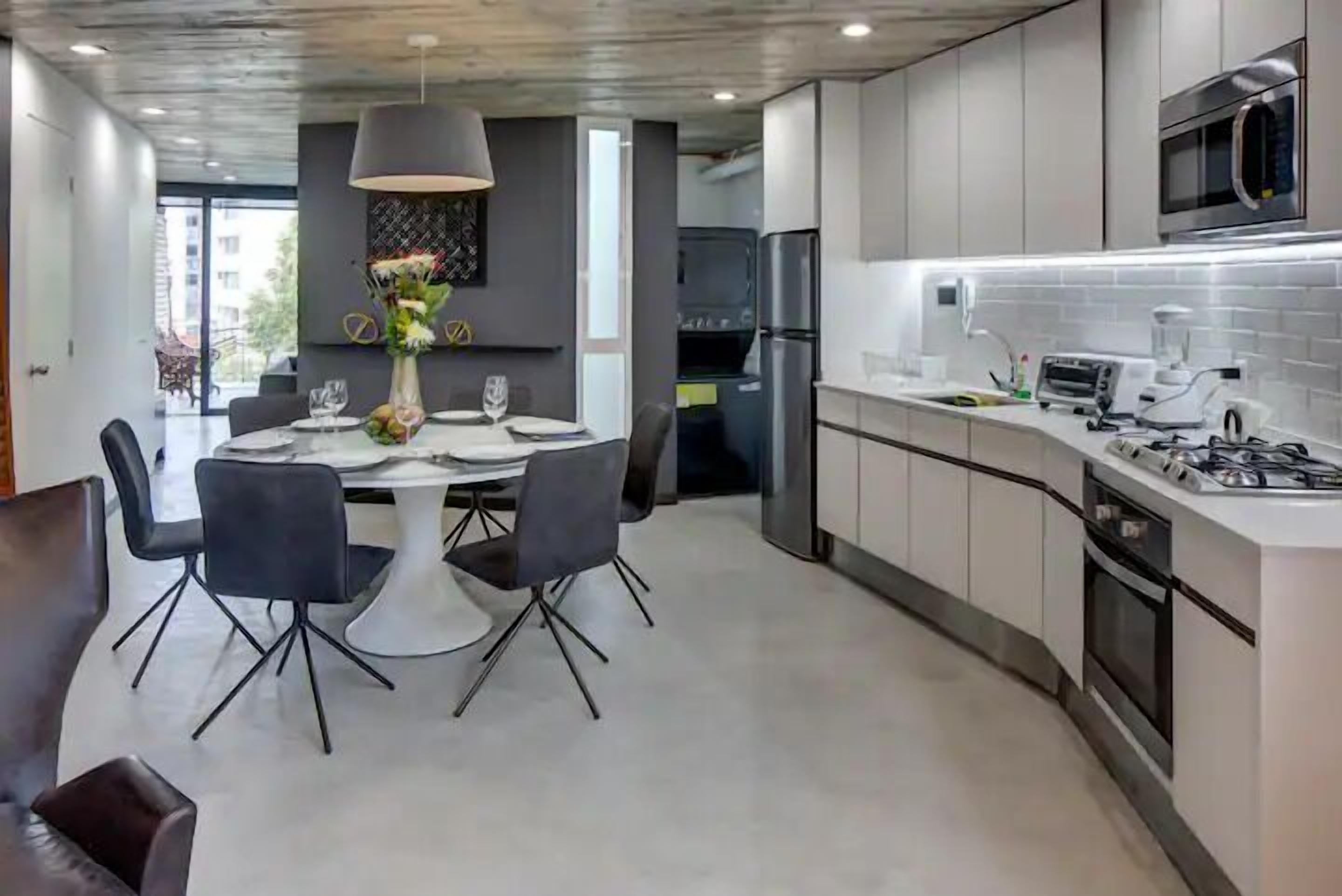 Een moderne keuken met witte kastjes, een ingebouwde magnetron en een gasfornuis.