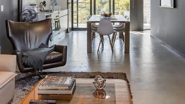 Una sala moderna con sofá, mesa de centro y zona de comedor.