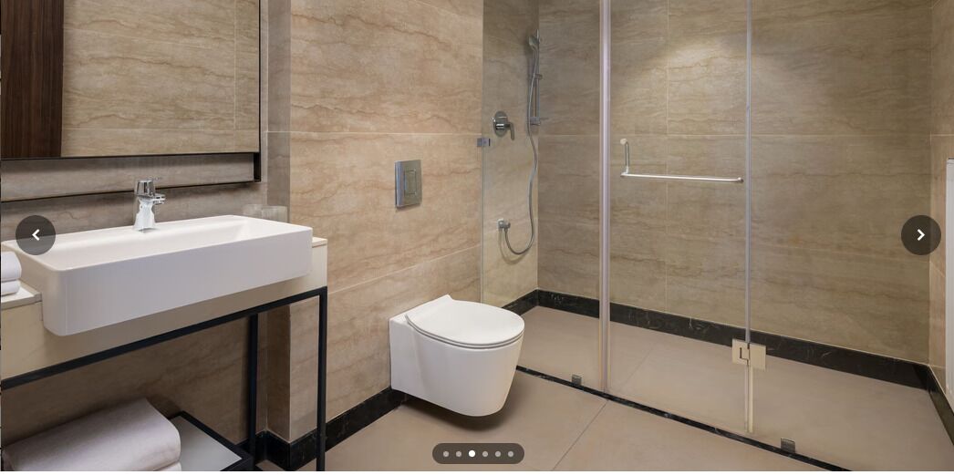 A modern bathroom with a glass-enclosed shower, a white sink, and a toilet.