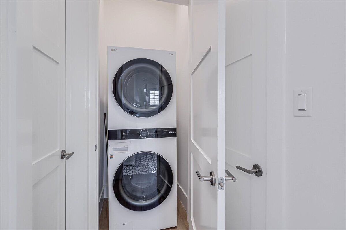 A laundry room with two stacked washing machines and dryers.