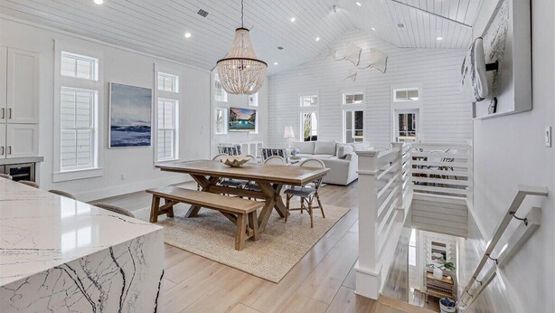 A spacious kitchen with a marble countertop, a wooden dining table, and a chandelier. - Sunnyside Up 209 LAK (Port Aransas)