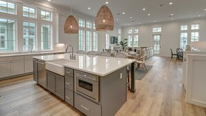 A spacious kitchen with a large island, ample natural light, and modern pendant lighting. - The Spanish Main 309 HI (Port Aransas)