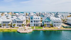 A coastal residential area with houses along a waterfront, featuring balconies and a dock. - Lakeside Luxury 230 LAK (Port Aransas)