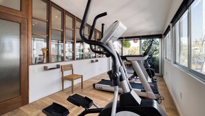 Ein Fitnessraum mit Laufbändern, einem Ergometer und einem Rudergerät.