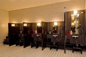 A public restroom with multiple stalls, each with a mirror, sink, and toiletries. - Hotel Dormy Inn Nagasaki Shinchichukagai (Nagasaki City)