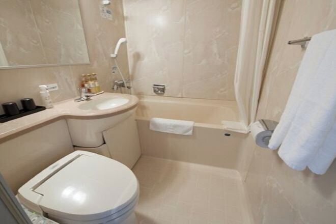 A bathroom with a toilet, sink, and bathtub.