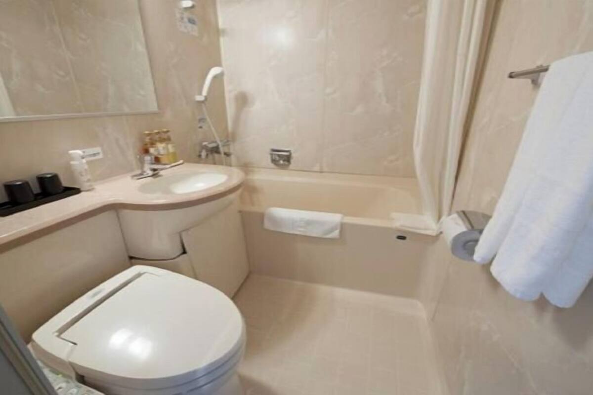 A bathroom with a toilet, sink, and bathtub.